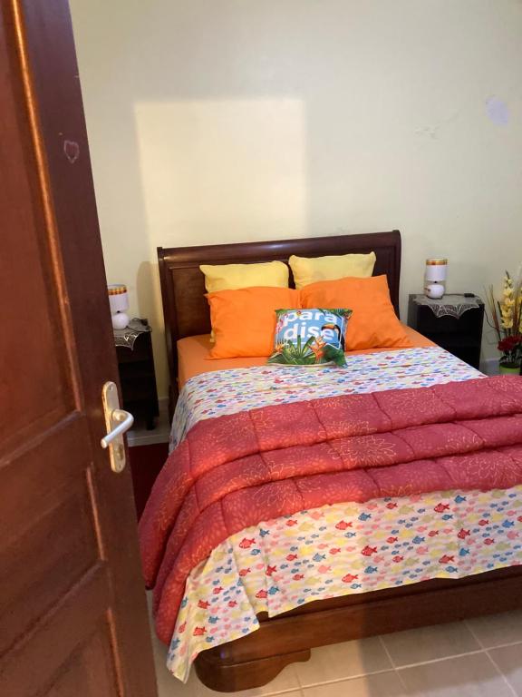 Basse-PointeLe refuge privatif de Julie的一间卧室配有带橙色枕头的床
