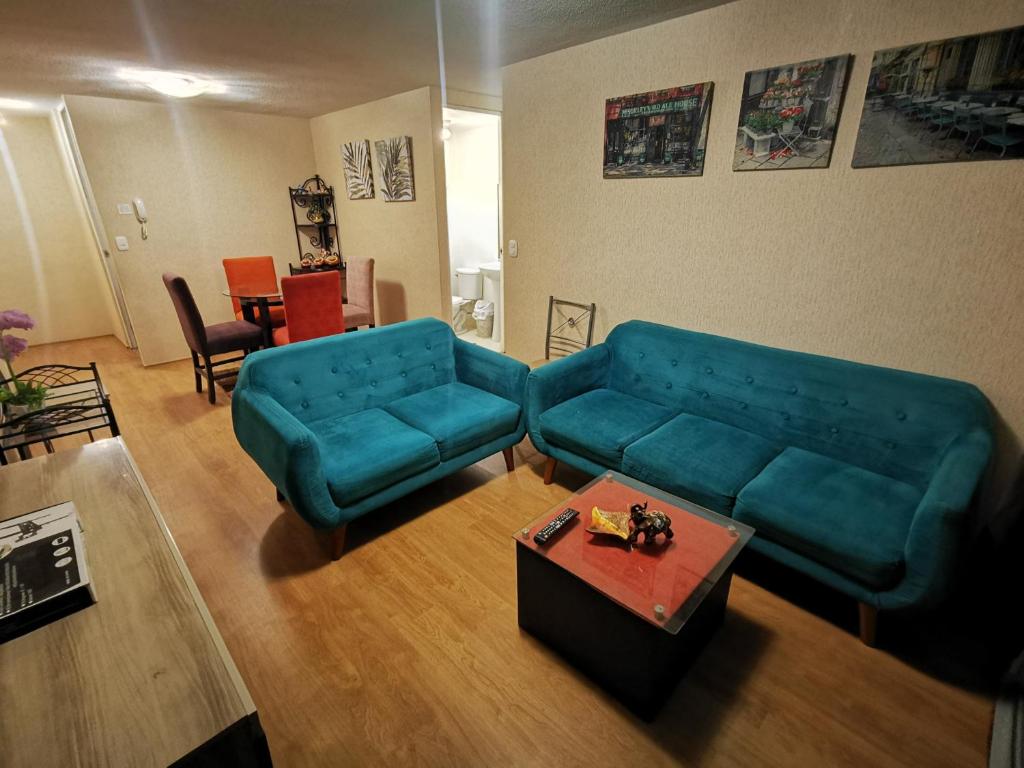 塔克纳Departamento amoblado en condominio - 5to piso的客厅配有蓝色的沙发和桌子