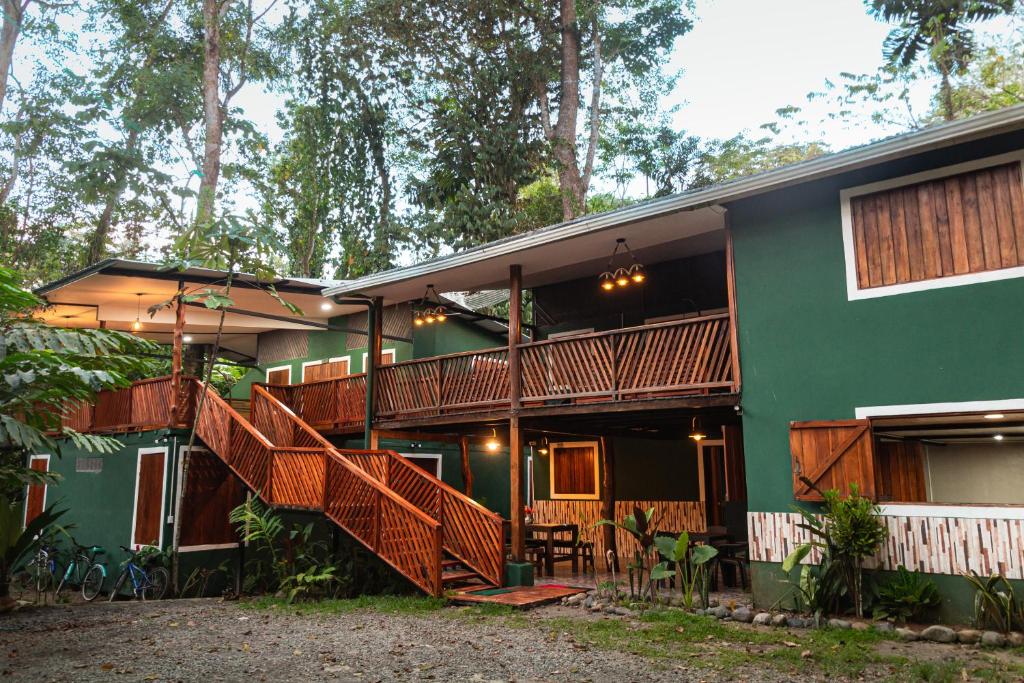 别霍港The Green Jungle & Tree House Caribe的前面设有木制楼梯的绿色房子
