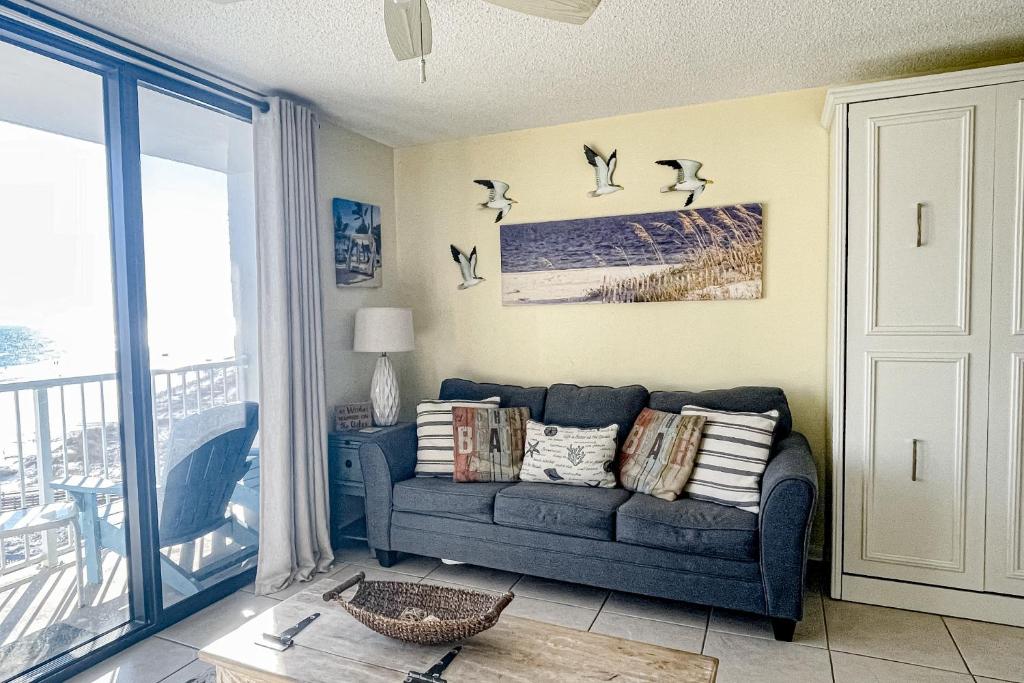 奥兰治比奇Seaside Beach & Racquet Club 3605的客厅配有沙发,墙上有鸟儿