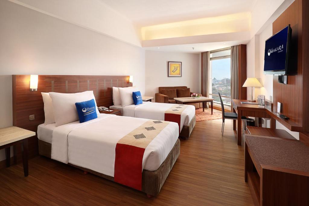 雅加达Hotel Bidakara Jakarta的酒店客房设有两张床和电视。