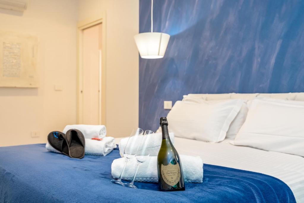 莱万托Appartamento Rina的床上的一瓶葡萄酒和毛巾