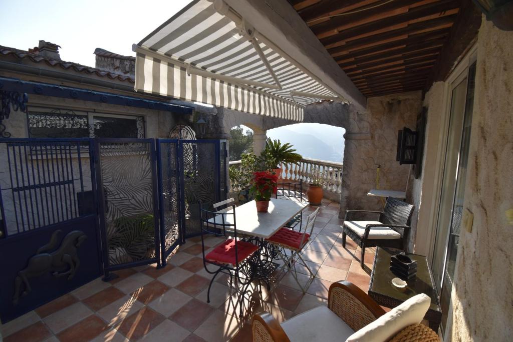 拉特里尼泰Studio climatisé et sa terrasse privée en villa的阳台的天井配有桌椅