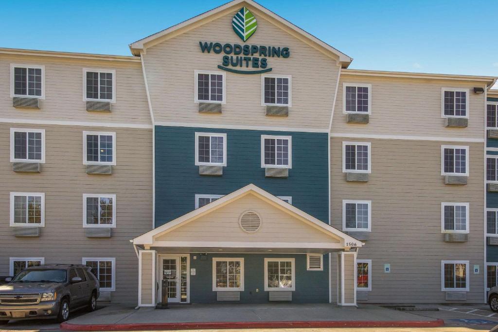 拉波特WoodSpring Suites Houston La Porte的停在前面的一辆卡车的建筑