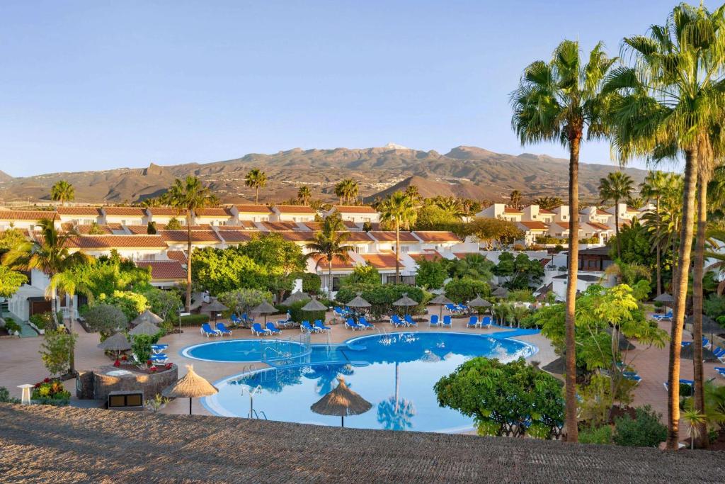 圣米格尔德阿沃纳Wyndham Residences Golf del Sur的享有度假村的空中景致,设有游泳池和棕榈树