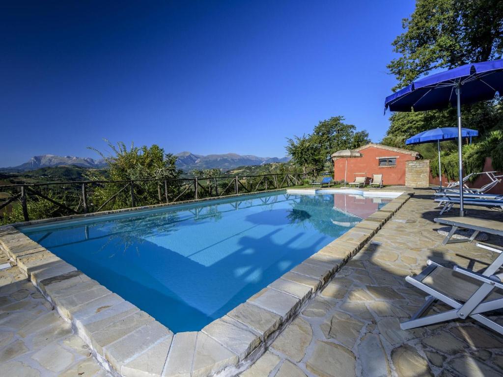 Monte San MartinoBelvilla by OYO La Priora的一个带两把椅子和遮阳伞的游泳池