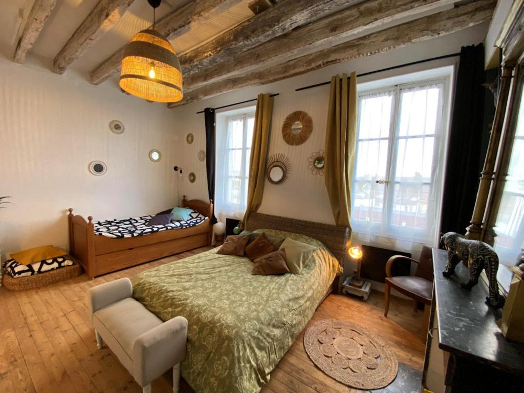 谢尔河畔努瓦耶Les petites Mirabelles的一间卧室配有一张床、一把椅子和窗户。