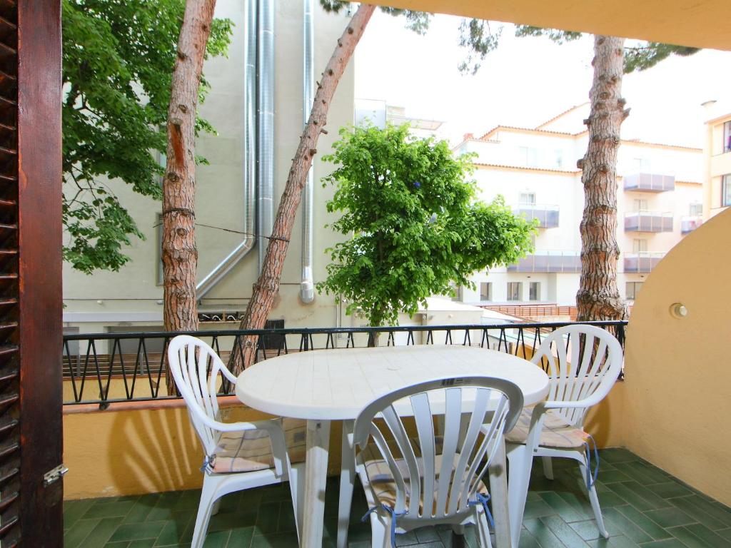 滨海托萨Apartment Aquarius by Interhome的树木繁茂的阳台配有白色的桌椅