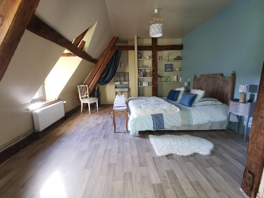 Sailly-FlibeaucourtLa Cour d'Hortense的一间卧室配有一张床,铺有木地板