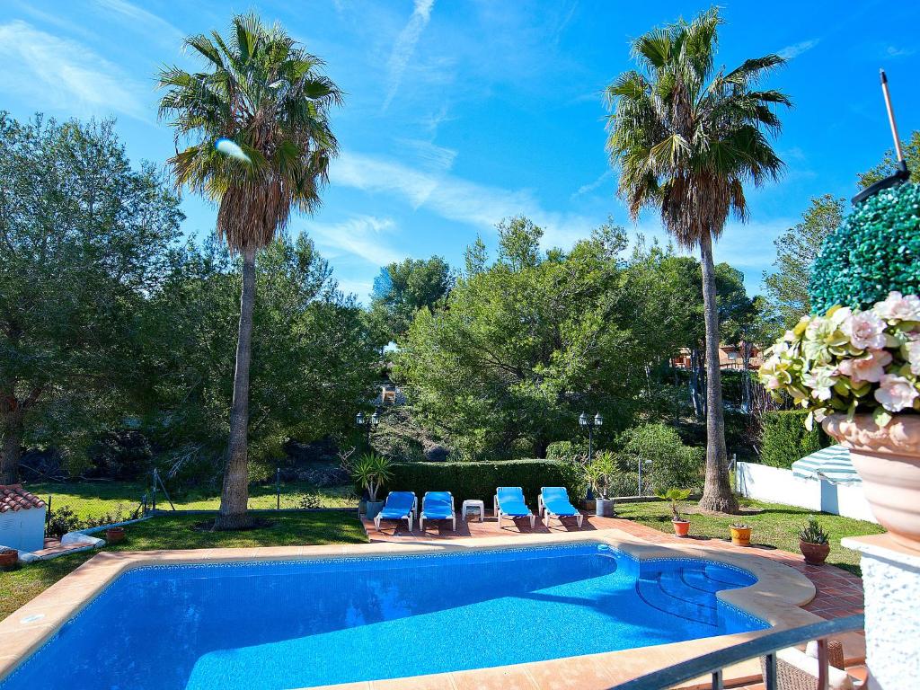 莫莱拉Holiday Home El sueno de Jeanne-Marie by Interhome的一个带两把椅子的游泳池,棕榈树