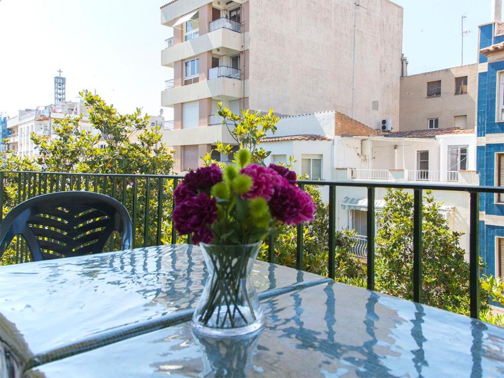 坎布里尔斯Apartment Carme by Interhome的阳台玻璃桌上的紫色花瓶