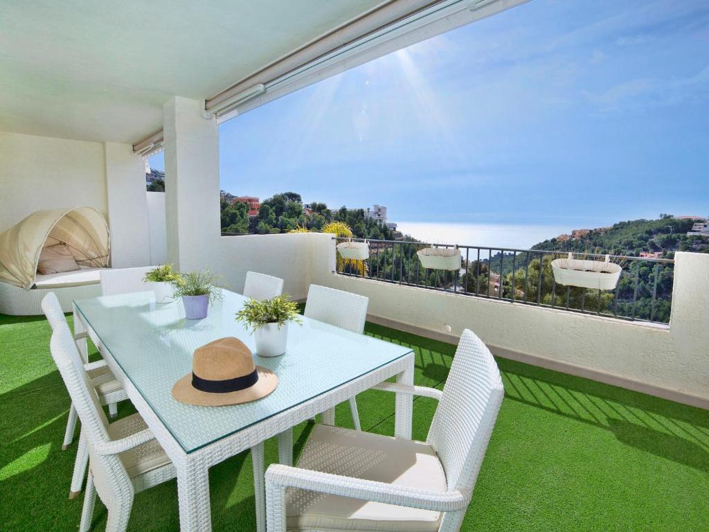 维耶亚高原Apartment Los Lirios-4 by Interhome的阳台的桌椅和帽子