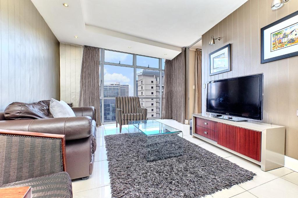 约翰内斯堡Comfort Apartment SA的客厅配有平面电视和沙发。