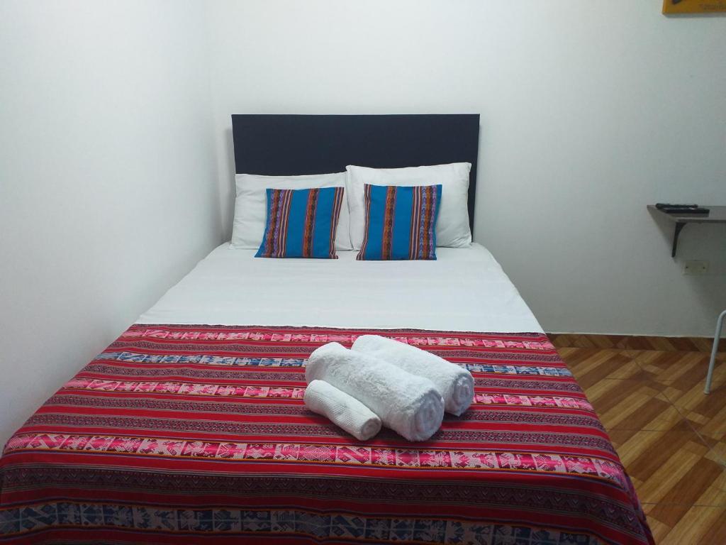 利马Chakana Family Home 2 Lima Airport的一间卧室配有一张床,上面有两条毛巾