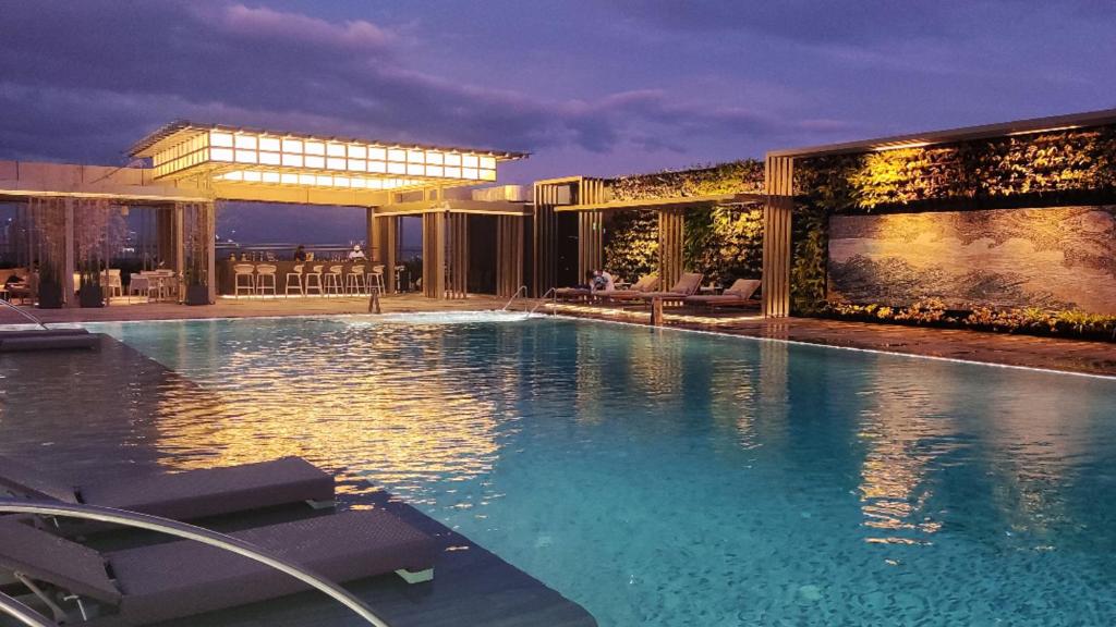 马尼拉Hotel Okura Manila - Staycation Approved的大楼前的大型游泳池