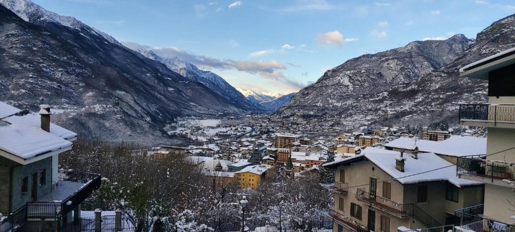 圣文森特Casa vista Saint Vincent accanto alle Terme的一座被雪覆盖的小镇,以群山为背景