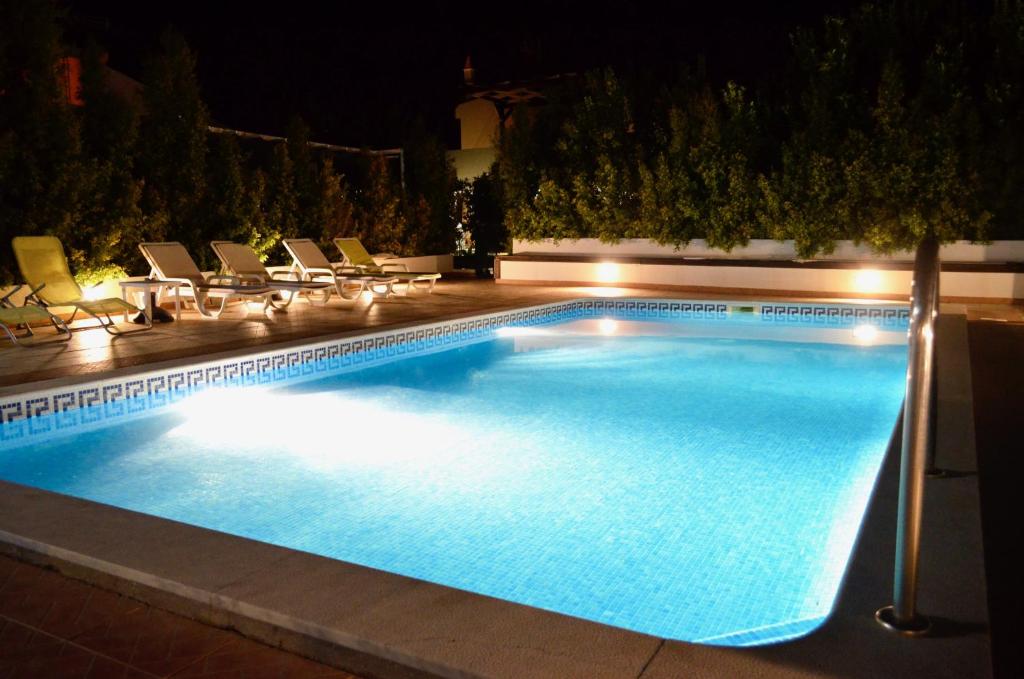 曼塔罗塔Villa ELTAEL - Rita Apartment - Warm pool until 5 Nov 2024的夜间游泳池,配有椅子和灯