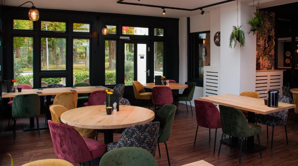 吉耶敦't兹瓦尼密尔酒店的餐厅设有桌椅和窗户。
