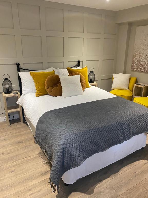 奥本Greenbank, Lower Greenbank Guest Suite的一间卧室配有一张带黄色和白色枕头的大床