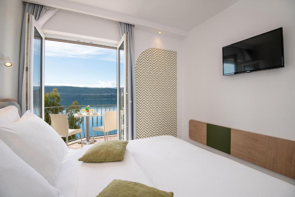 内乌姆诺瓦别墅酒店的一间卧室设有一张床,享有阳台的景色