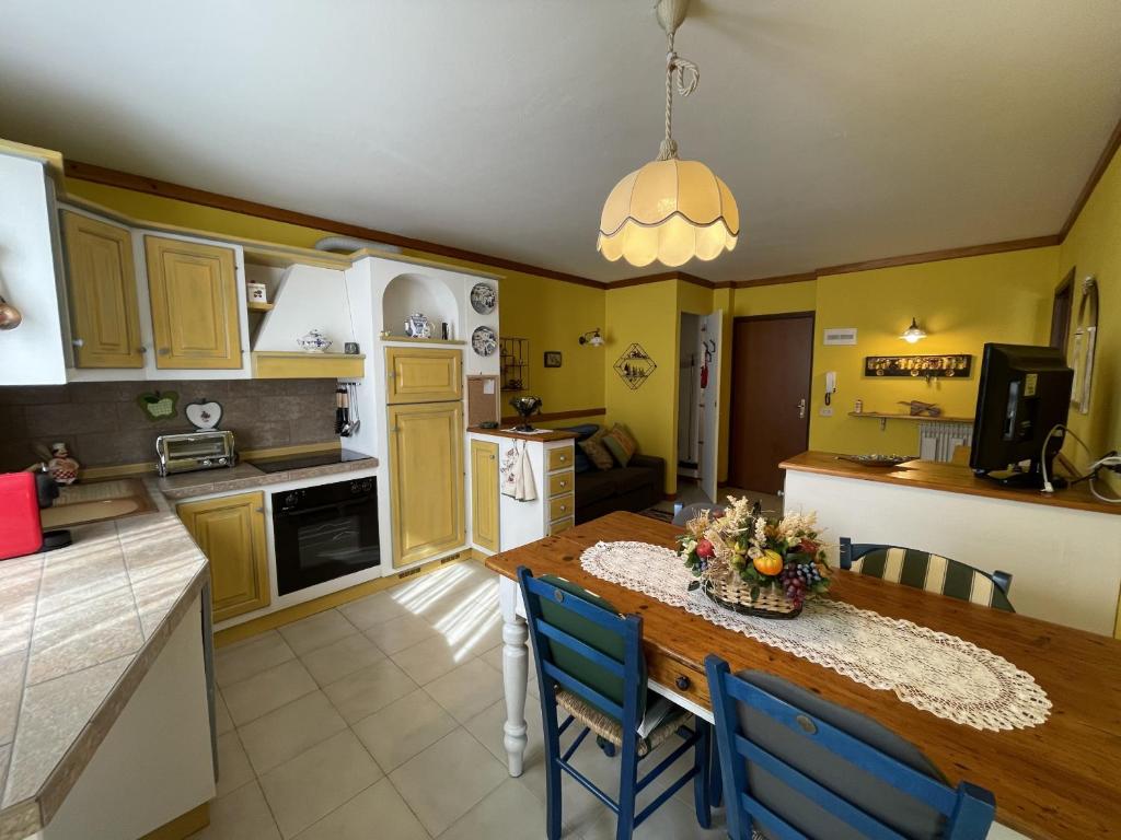 Giustino072 Trilocale, Giustino的厨房配有木桌和蓝色椅子