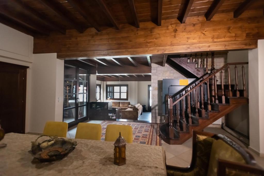 卡尔派尼西翁Kourtis Family Mansion的客厅设有餐桌和楼梯。