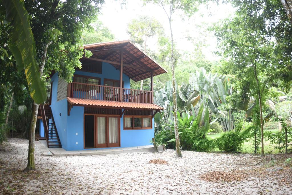 库穆鲁沙蒂巴Chalés Cumuruxatiba的森林中带阳台的蓝色房屋