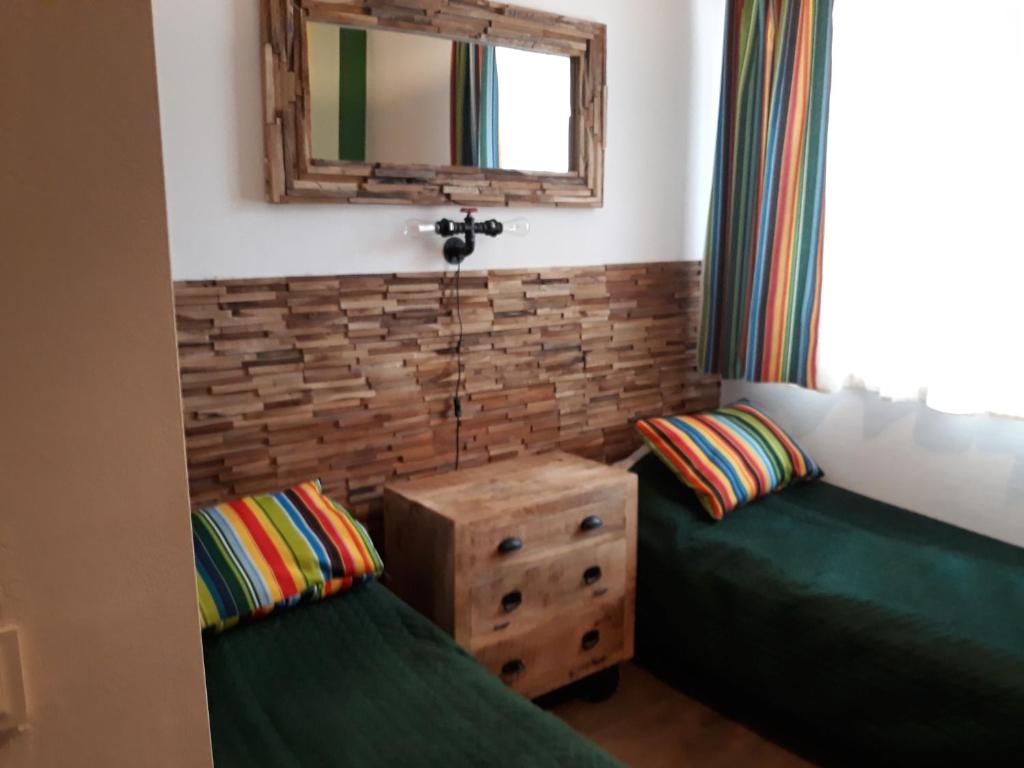 Krępa雄鸡村庄农家乐的客房设有两张绿色的床和镜子