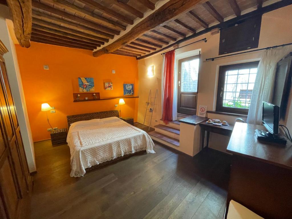 蒙特普齐亚诺Dimora Del Corso Di Montepulciano的一间卧室拥有橙色的墙壁,里面设有一张床