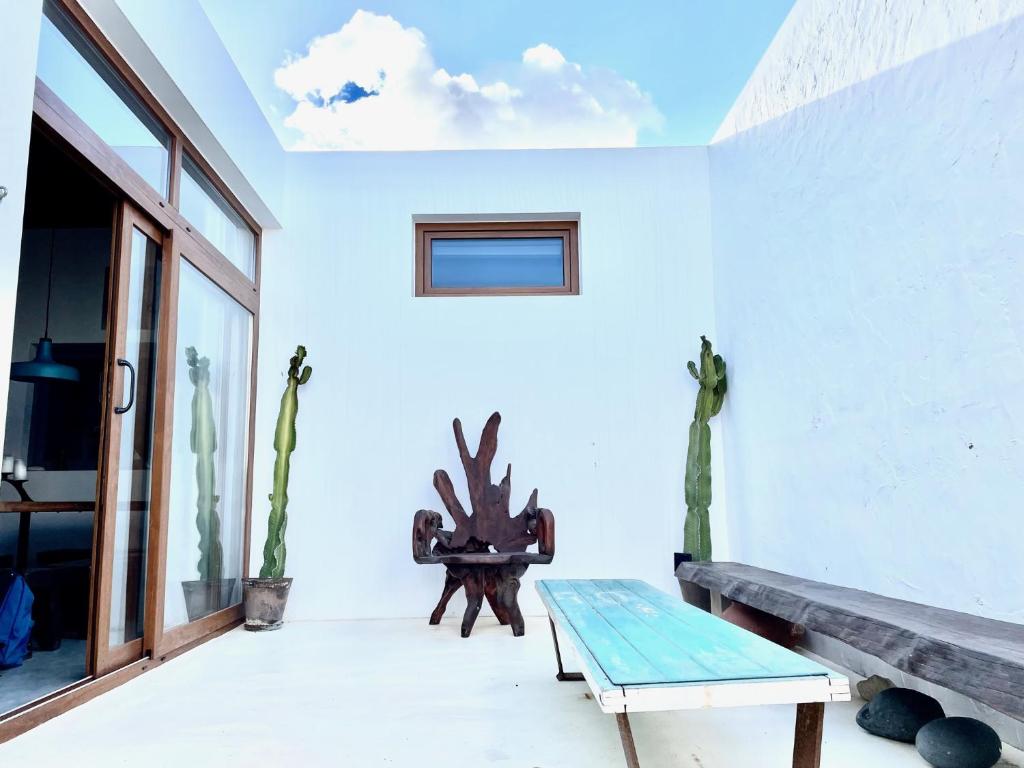 塞博河畔卡莱塔VILLA RELAX, LA GRACIOSA的一间设有桌子、长凳和窗户的房间