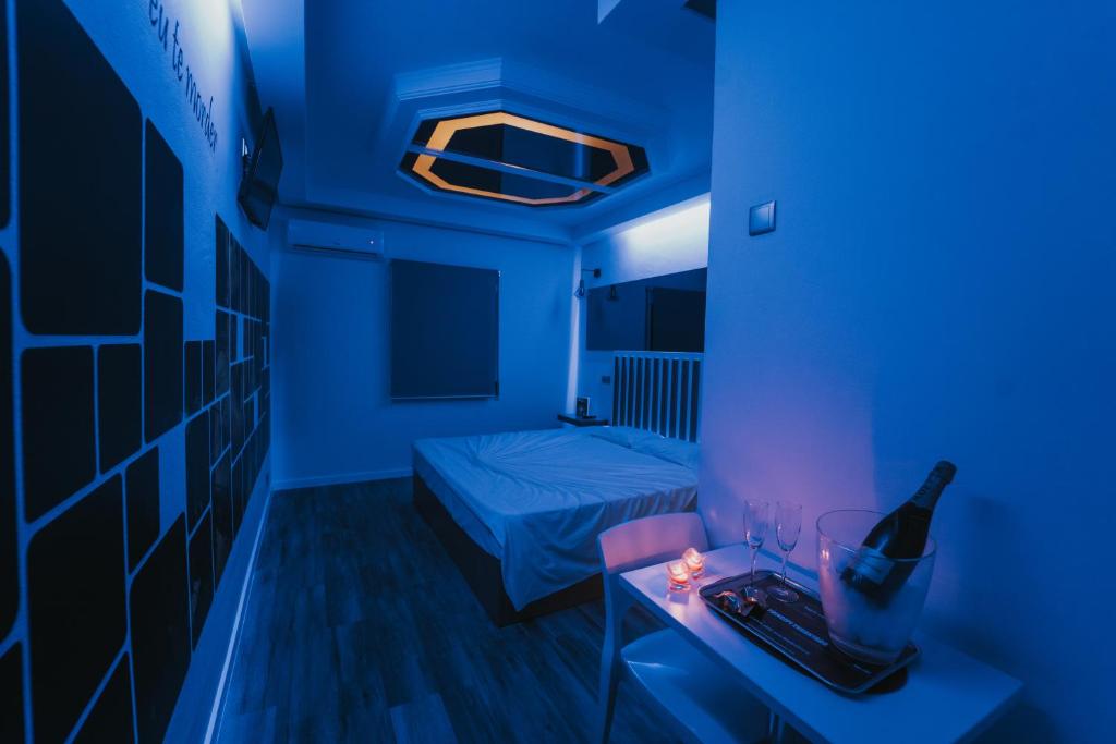 梅阿利亚达Motel Príncipe Encantado的蓝色客房 - 带一张床和一瓶葡萄酒