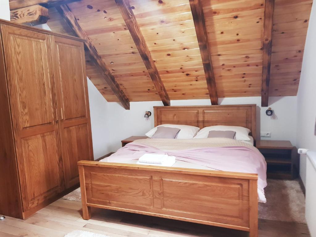 普利特维采湖Plitvice Green Valley的一间卧室设有木床和木制天花板。