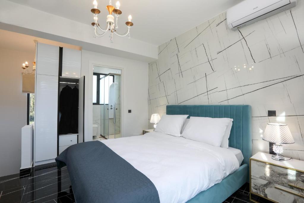 古维亚Rans Luxury Villas & Suites in Corfu with swimming pool的卧室配有一张白色大床和吊灯。