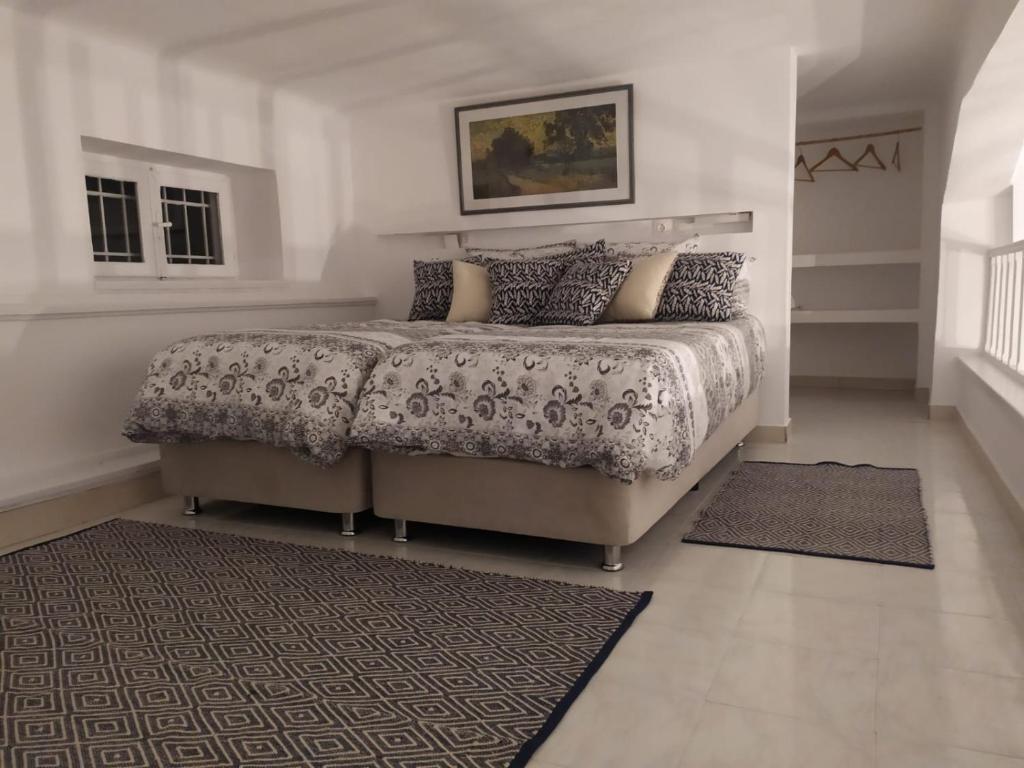 卡利诺岛Kalymnos Gallery的一间卧室配有一张大床和地毯。