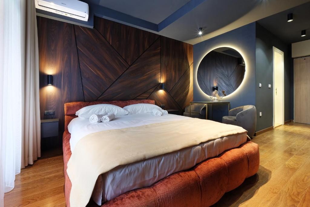 贝尔格莱德Belgrade Waterfront Apartments - Arcadia的一间卧室配有一张大床和大型木制床头板