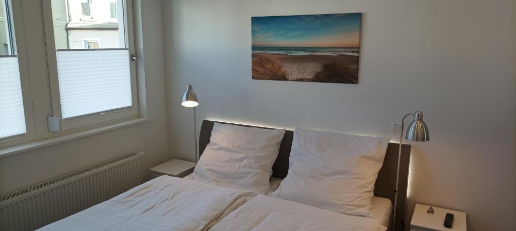 代特莫尔德Detmold City Premium Appartement H17的一间卧室配有带白色床单和枕头的床。