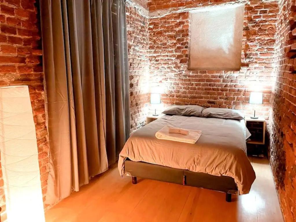 墨西哥城Mina 32 - Coyoacan的卧室配有砖墙内的床铺