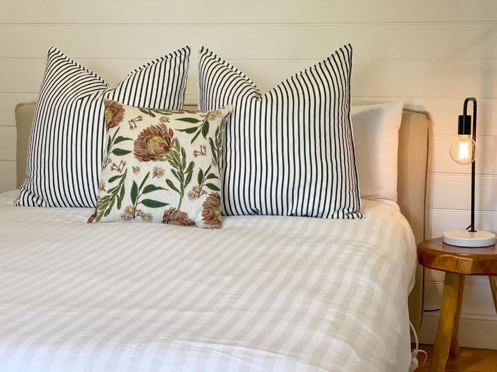 滕特菲尔德Blue Duck Cottage Village Comfort with Fireplace的一张带四个枕头的床和一张白色的床