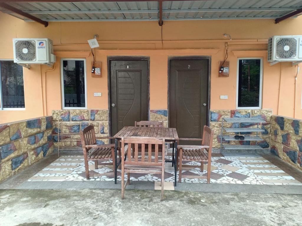 拉瑙Homestay pekan ranau的房屋庭院里的桌椅