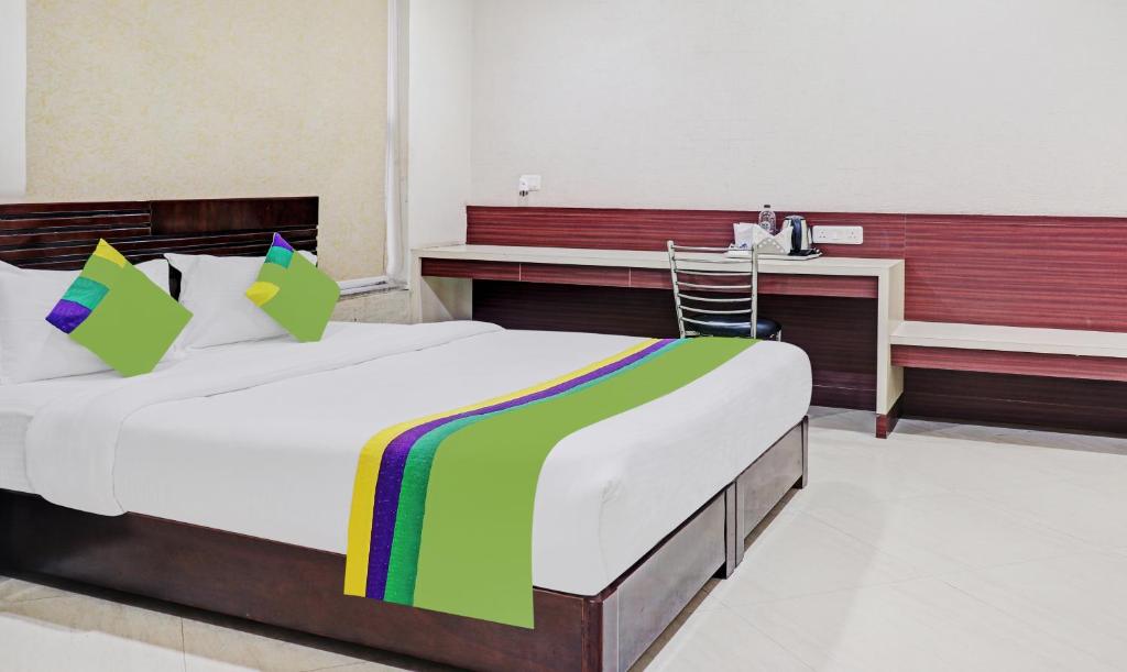 兰奇Treebo Trend Elite City Upper Bazar的一间卧室配有一张大床和一张书桌