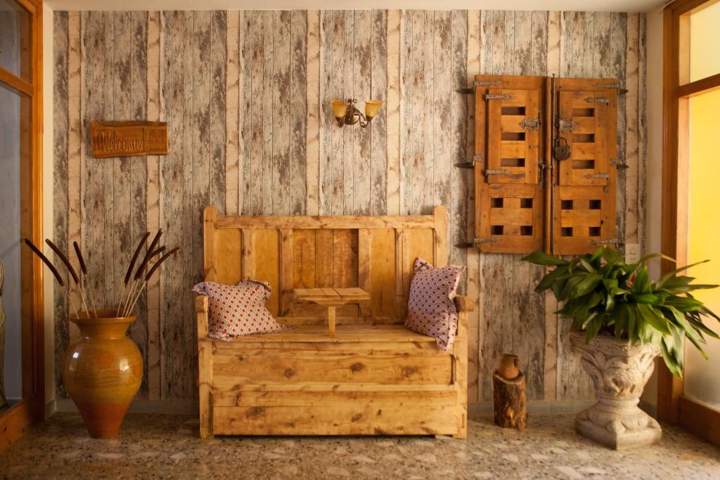 努瓦洛斯Apartamentos rurales La posada de Donato的客房设有带长凳和枕头的木墙。