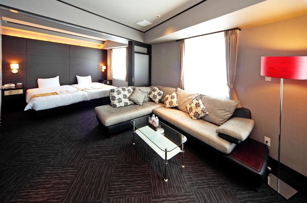堺市萨凯太阳广场酒店的酒店客房设有一张沙发和一张床