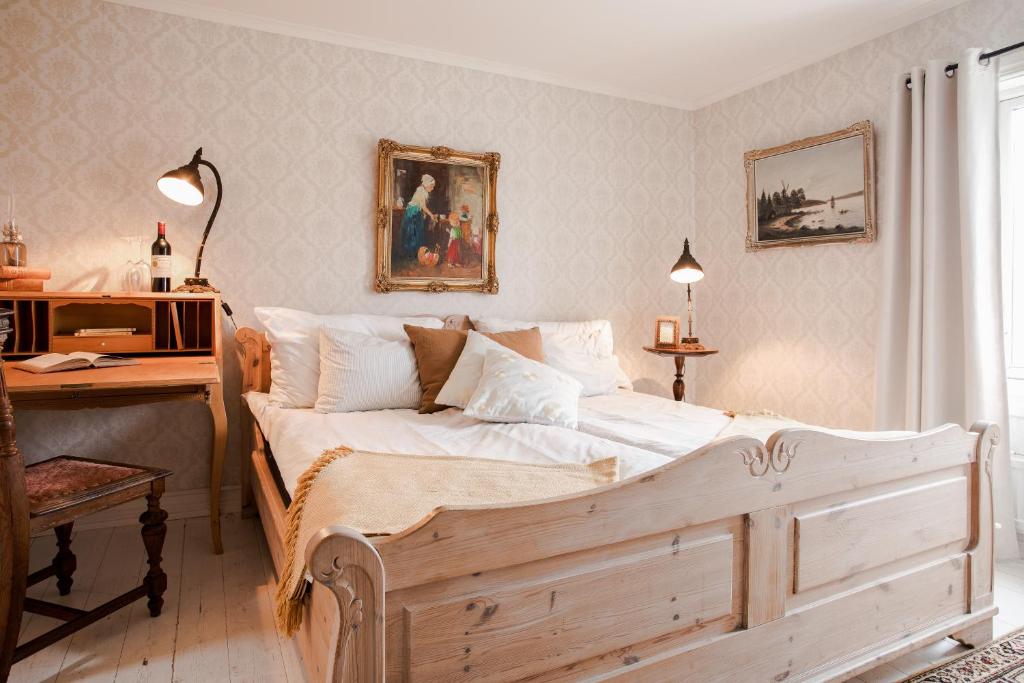 吕瑟希尔吕瑟希尔大酒店的一间卧室配有一张木床、一张桌子和一张书桌。