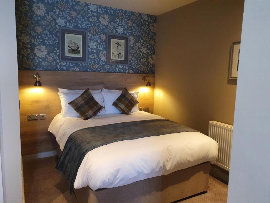 斯基普顿Old Swan的一间卧室配有一张带蓝色壁纸的大床