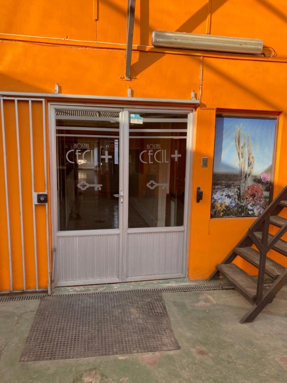 巴耶纳尔Hostal CECIL +的橙色的建筑,有门和窗户