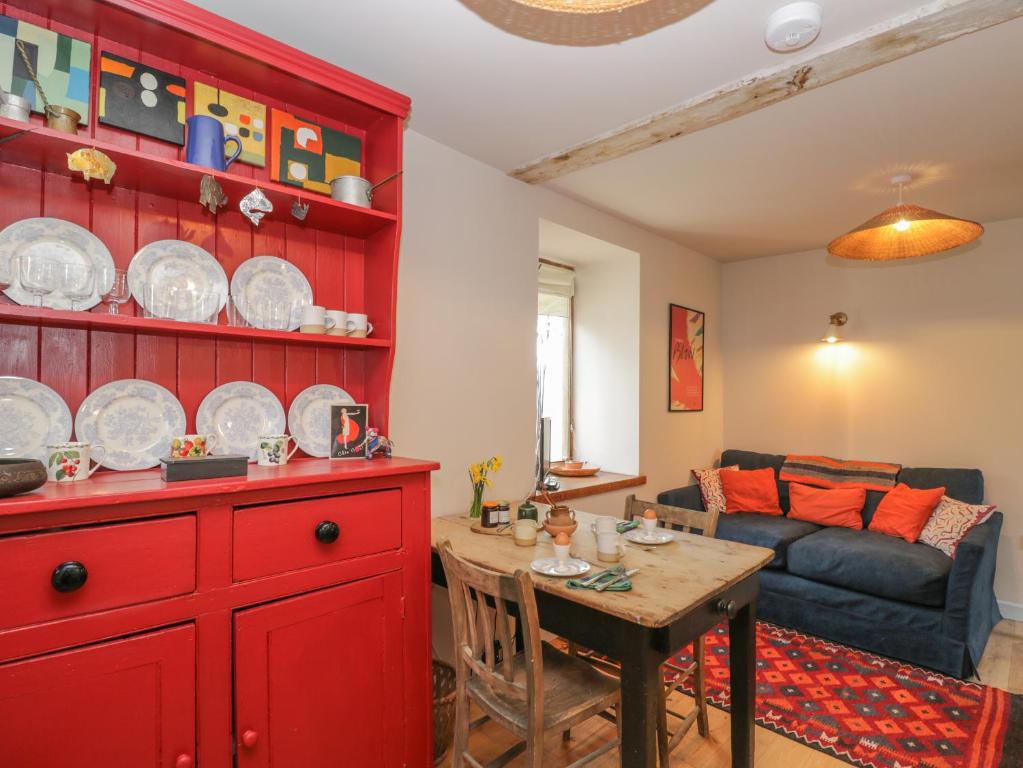 阿斯克The Old Stables的客厅配有红色橱柜和桌子