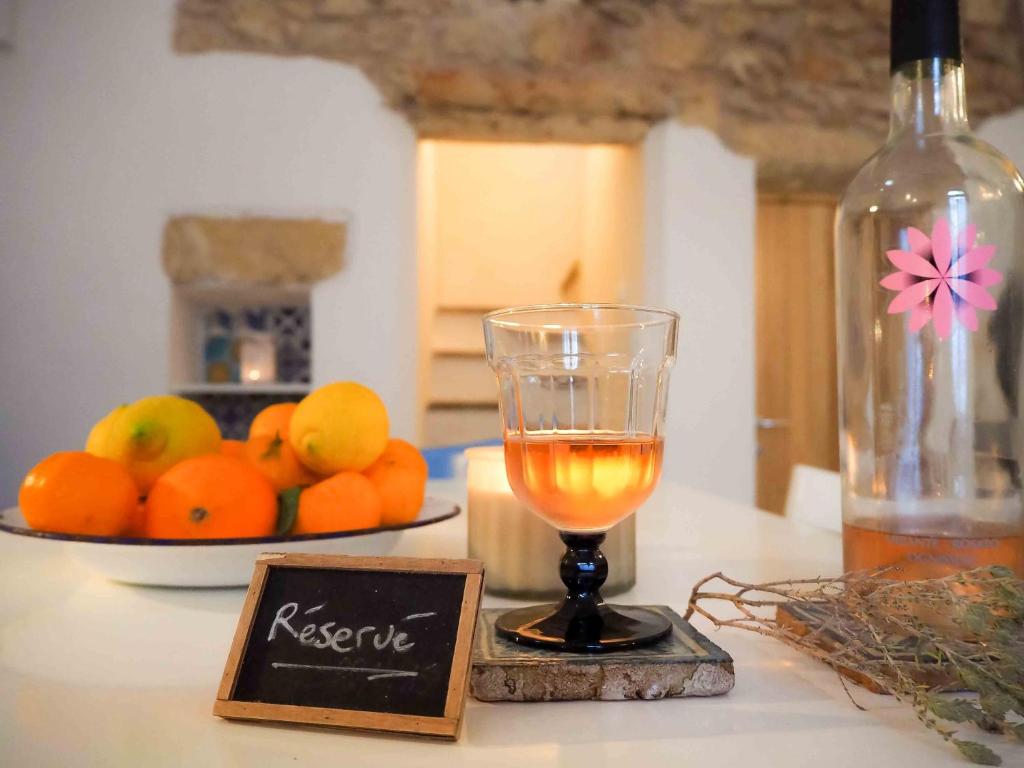 莱韦拉诺Antica Dimora Salentina的一杯酒,放在桌子上,放上一盘橙子