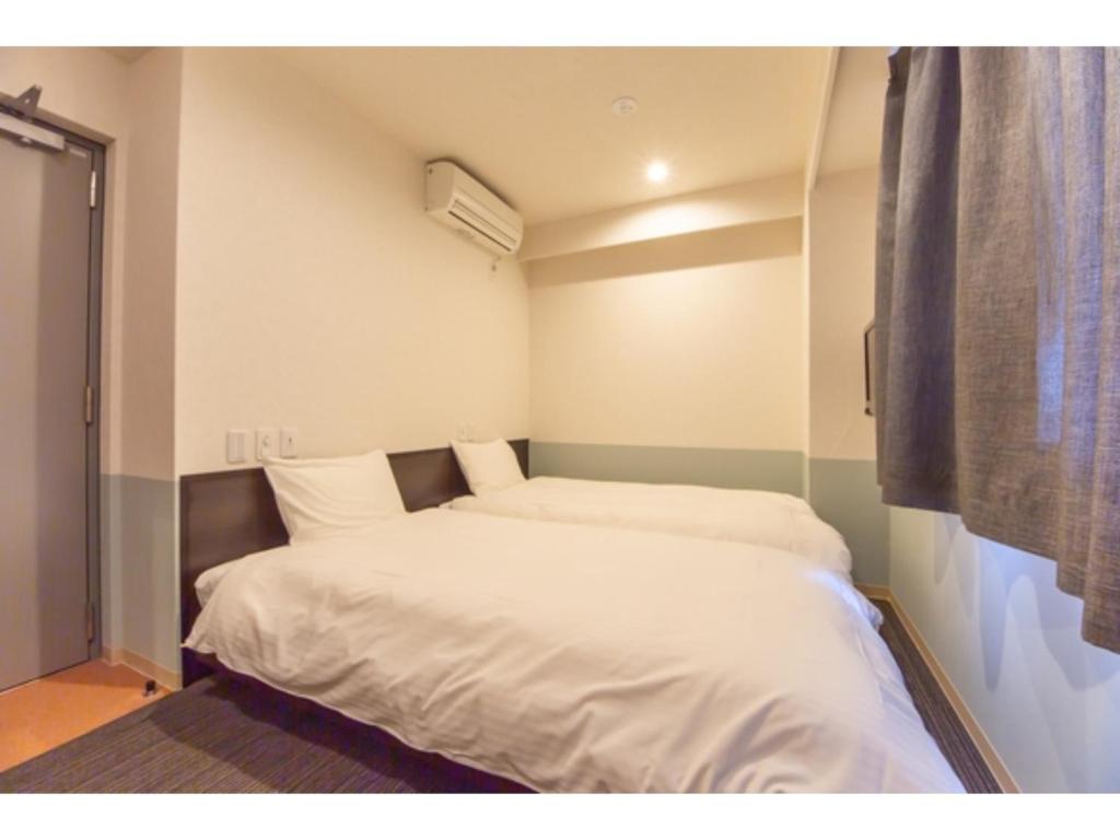 德岛Hotel Taiyonoen Tokushima Kenchomae - Vacation STAY 26347v的一间小卧室,内配两张床