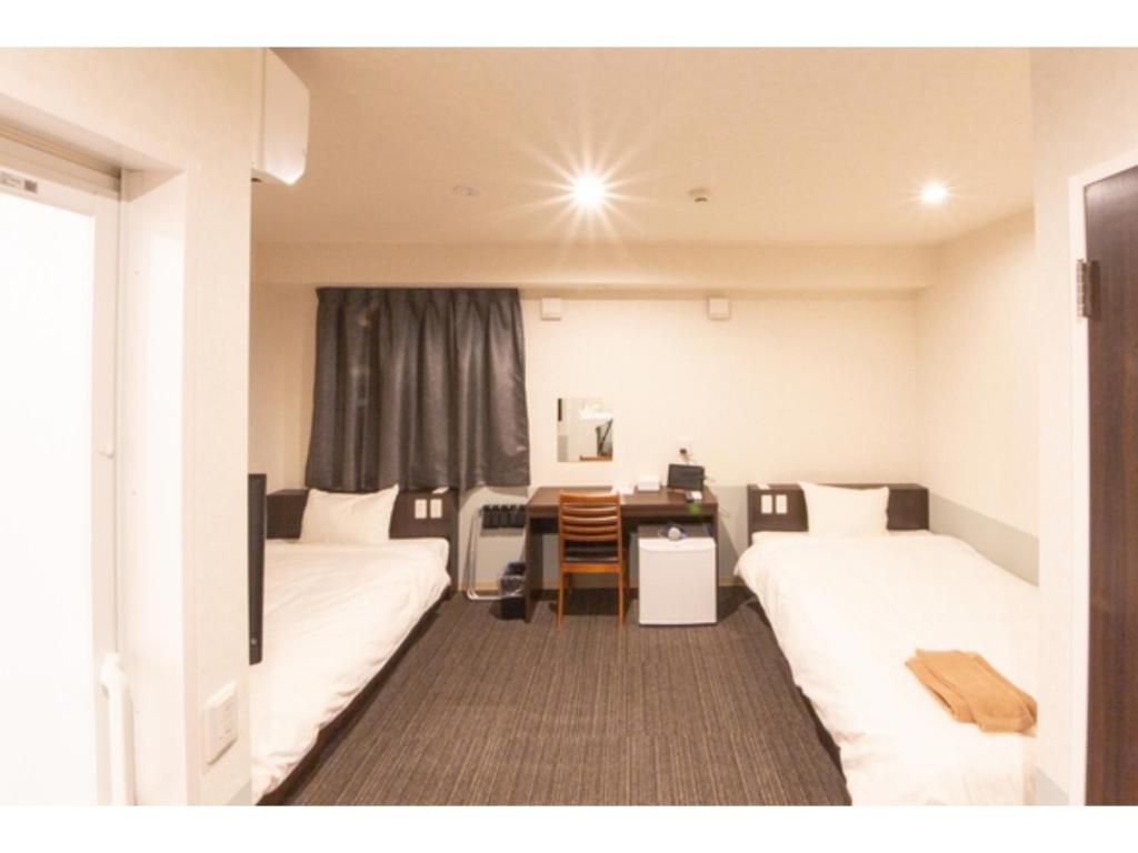 德岛Hotel Taiyonoen Tokushima Kenchomae - Vacation STAY 26355v的酒店客房配有两张床和一张书桌