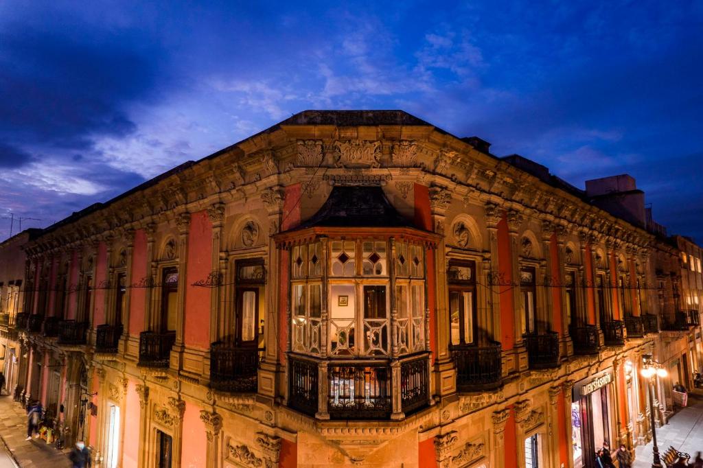 圣路易斯波托西Iturbide500 hostal的一座古老的建筑,旁边设有阳台